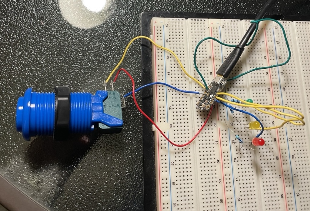 Photo of electronics breadboard with various wires and buttons attached.