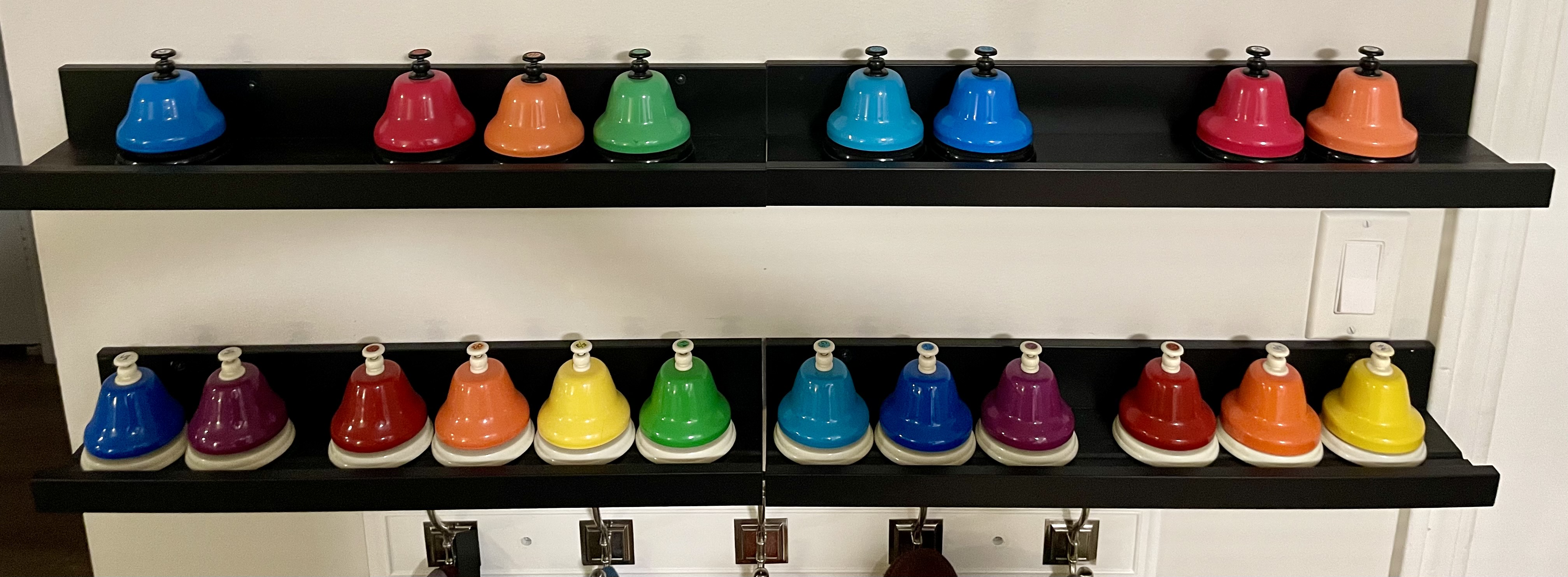 Photo of two rows of rainbow desk bells.