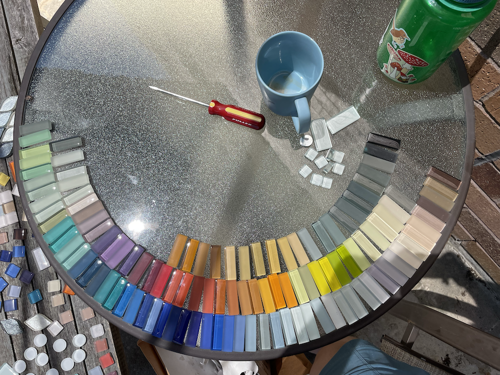 Photo of rectangle glass tiles in an assortment of colors, arranged in color order on a circular table
