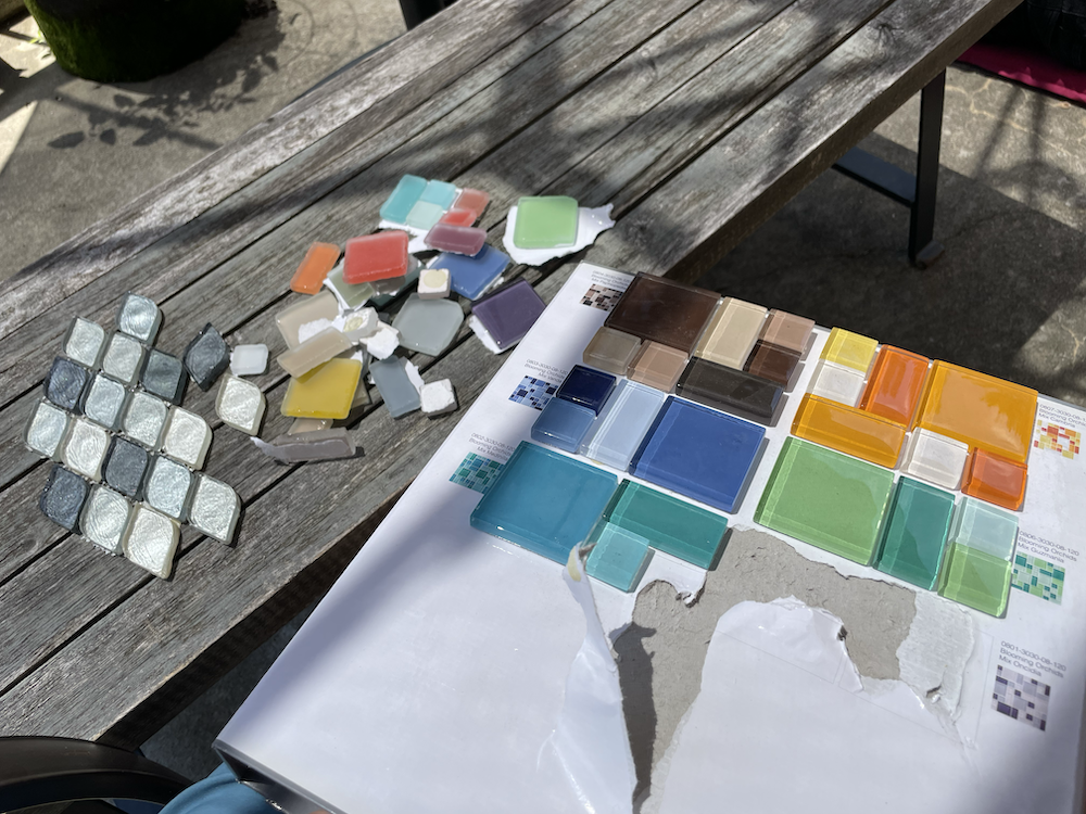 Photo of glass tiles being removed from cardboard binder
