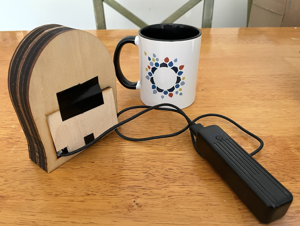 Photo of assembled speaker from the back next to mug